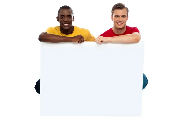Casual jonge jongens poseren met lege billboard — Stockfoto