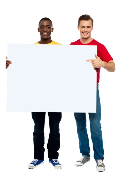 Улыбающиеся парни с белой рекламной доской — стоковое фото
