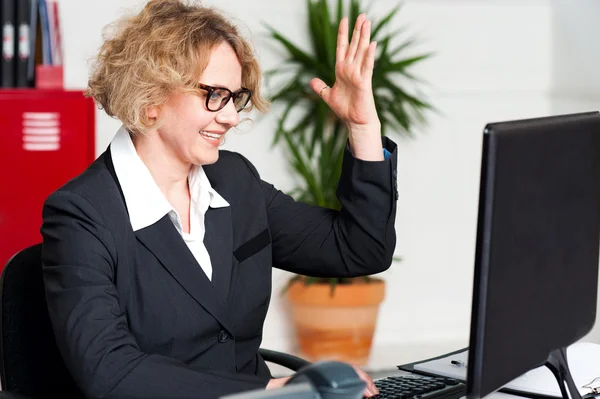Smiling woman with raised arm looking at screen — Stock Photo, Image