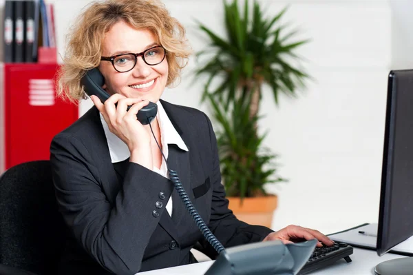 Front desk lady attending clients call — Stock Photo, Image