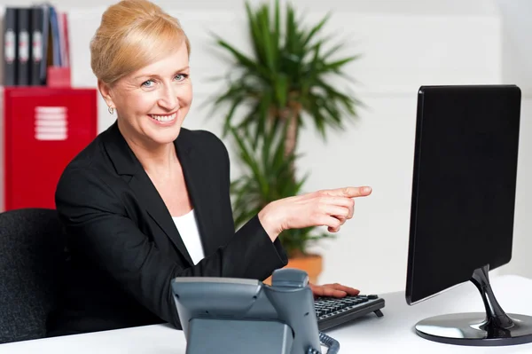 Businesswoman pointing at computer screen — Stock Photo, Image