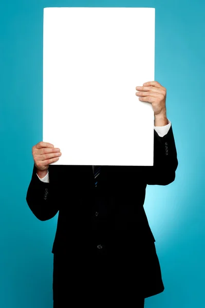 Manager verbergen van zijn gezicht achter witte reclamevaandel — Stockfoto