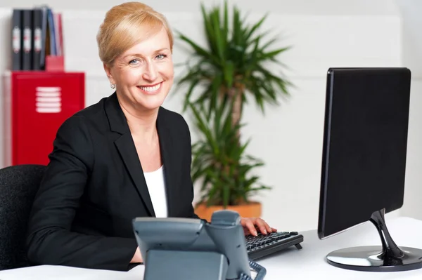 Sorrindo mulher corporativa digitando no teclado — Fotografia de Stock