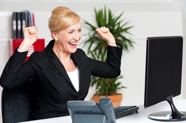 Senhora corporativa animado olhando para a tela do computador — Fotografia de Stock