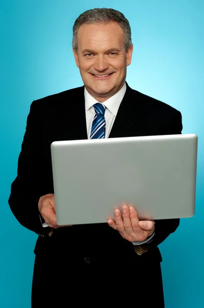 Uśmiechający się w wieku wykonawczy posiadania laptopa — Zdjęcie stockowe
