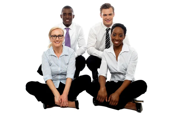 Quatro colegas de negócios sentados no chão — Fotografia de Stock