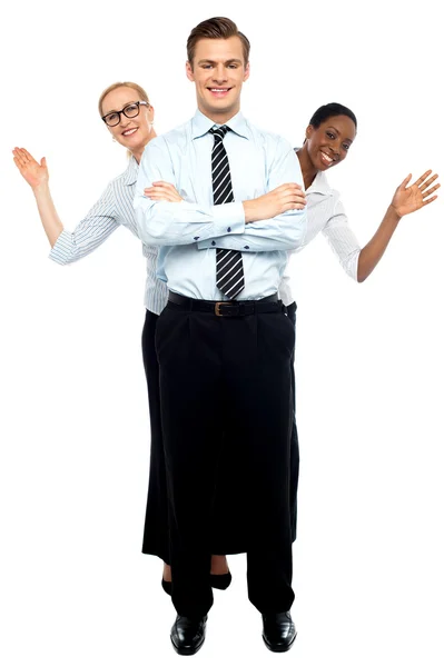 Female corporate waving hi while man stands tall — Stock Photo, Image