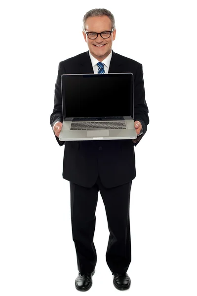 Hombre de negocios envejecido mostrando portátil recién lanzado — Foto de Stock