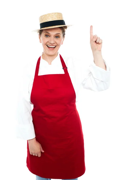 Joyful middle aged cook pointing upwards — Stock Photo, Image
