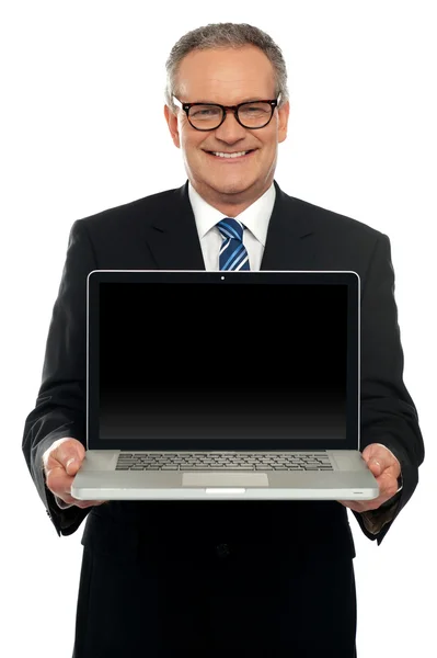 Executivo sênior de pé com laptop aberto — Fotografia de Stock