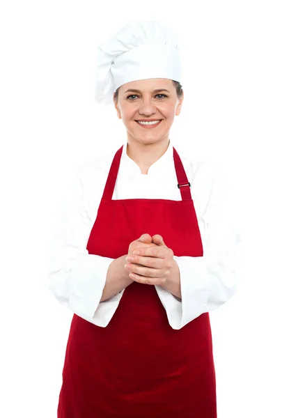 Усміхнений старий кухар стоїть в червоній формі — стокове фото