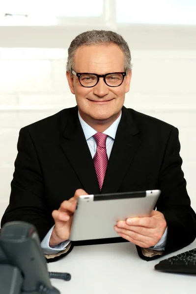 Główny prokurent siedzi z komputera typu tablet w ręce — Zdjęcie stockowe