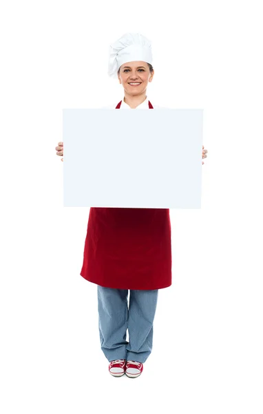 Chef sorrindo exibindo placa de publicidade branca — Fotografia de Stock