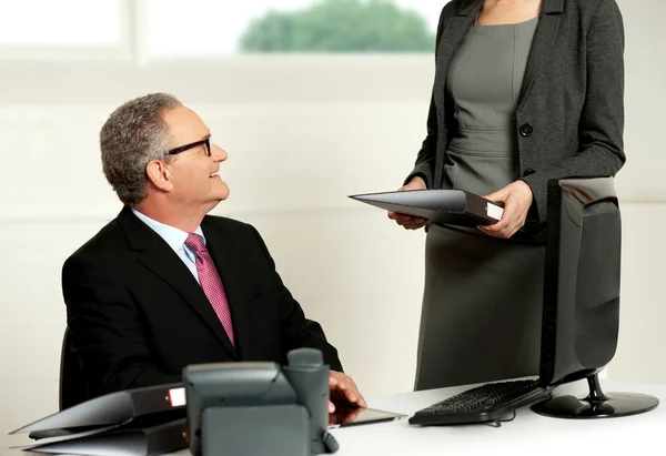 Smiling aged male boss looking at secretary — Stock Photo, Image