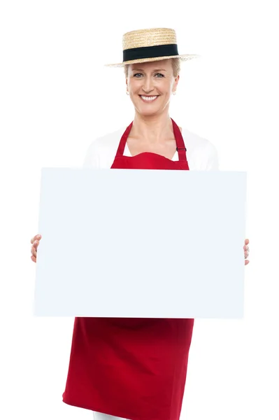 Portrét ženské šéfkuchaře v klobouku s prázdné reklamní desky — Stock fotografie