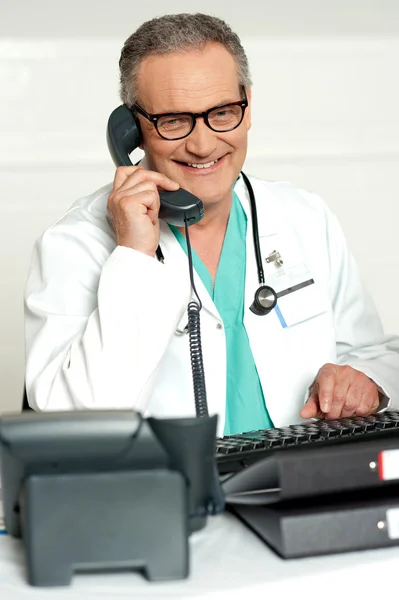 Reifer Arzt kommuniziert am Telefon — Stockfoto