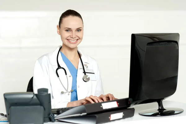 Uśmiechnięta kobieta lekarz pracuje na komputerze — Zdjęcie stockowe