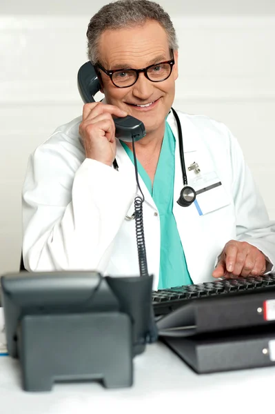 Glücklich gealterte Medizinerin greift zum Telefon — Stockfoto