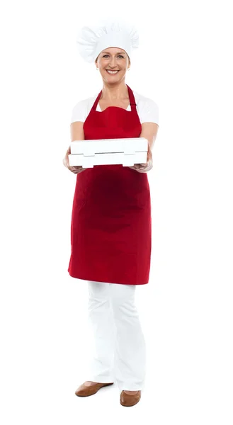 Ganzkörperporträt einer Köchin, die Pizza anbietet — Stockfoto