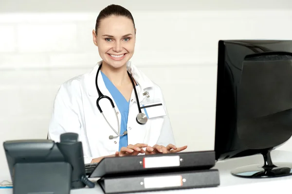 Vrolijke vrouwelijke arts koppelverkoop op toetsenbord — Stockfoto
