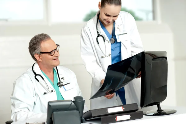 Team of two doctors reviewing x-ray report — Stock Photo, Image