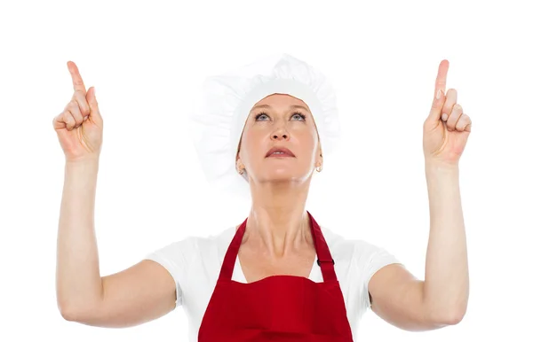 Female chef in uniform pointing upwards — Stock Photo, Image
