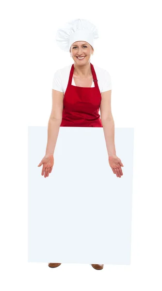 Belo chef mostrando placa branca em branco — Fotografia de Stock