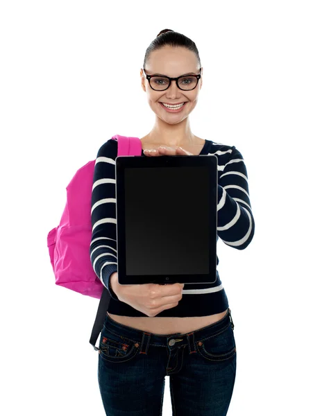 Chica universitaria mostrando dispositivo de pantalla táctil en blanco — Foto de Stock