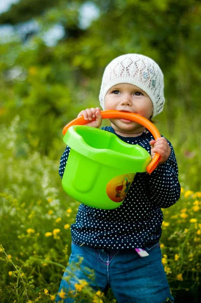 Little girl with a bucket in mouth — Stock Photo, Image