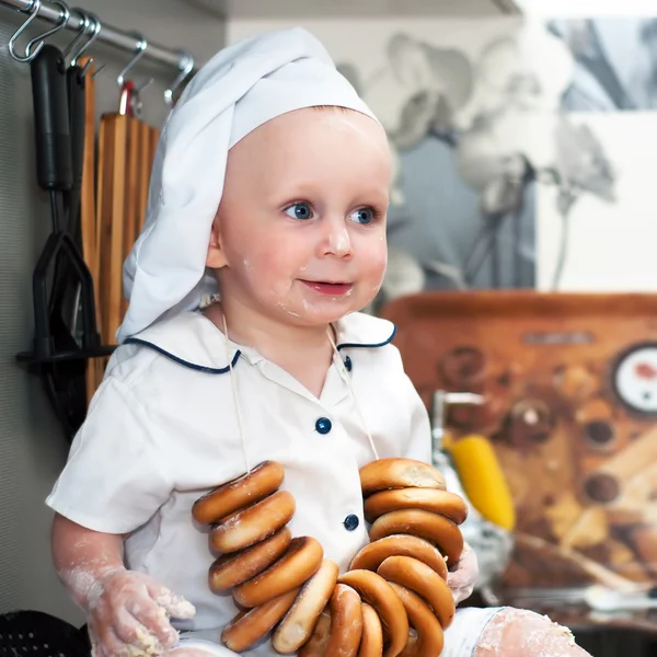 Porträt eines Babys mit Kochmütze, das in einem großen Kochtopf sitzt — Stockfoto