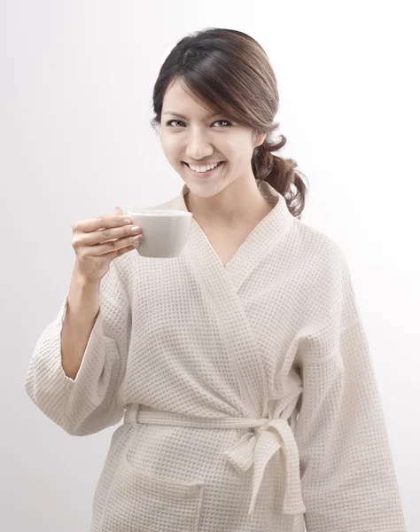 亚洲女人穿浴袍举行在白色背景上的一杯咖啡 — 图库照片