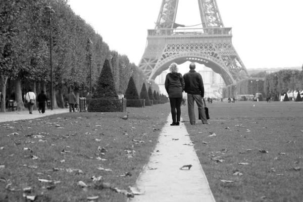 Pár turistických sledování Eiffelova věž ve vzdálenosti. — Stock fotografie