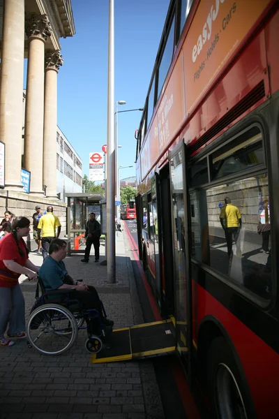 Man i rullstol att komma på en allmän buss — Stockfoto