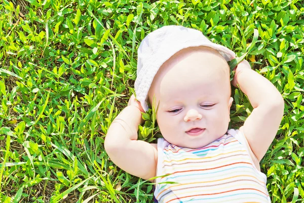 Маленька сновидіння дитина лежить на траві — стокове фото