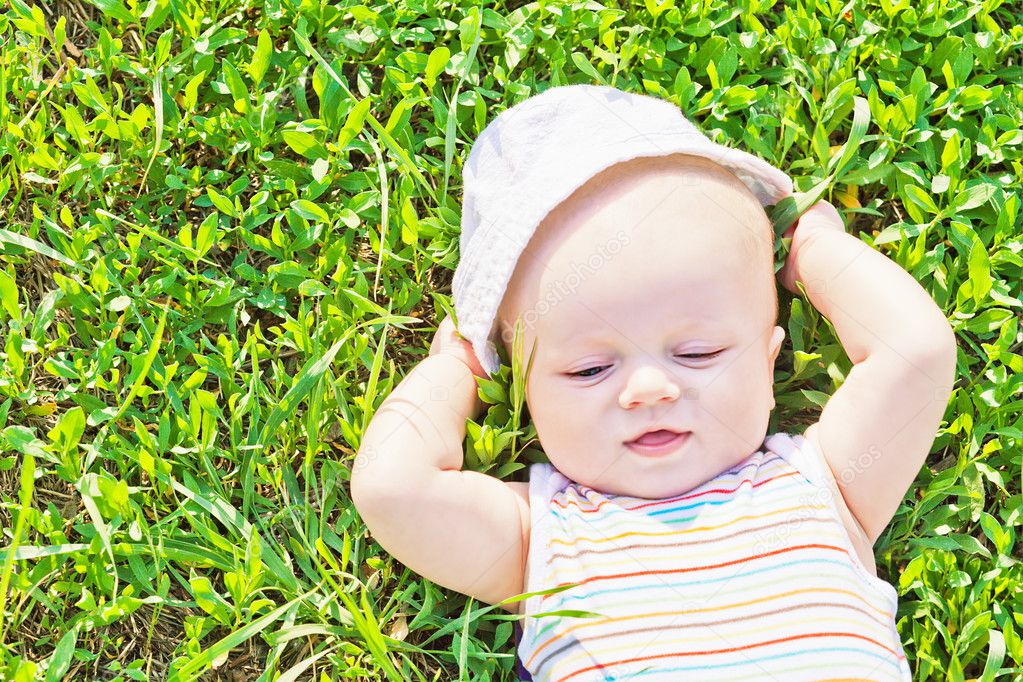 Little dreaming baby laying on the grass