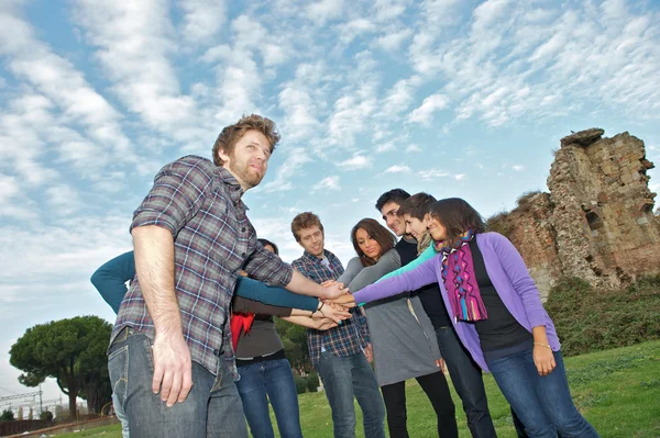 Estudiantes multirraciales con manos en la pila — Foto de Stock