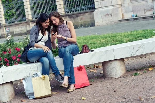 Δύο φίλες στο πάρκο με ένα κινητό τηλέφωνο — Φωτογραφία Αρχείου