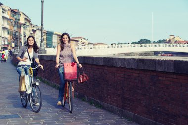 Two Beautiful Women Going by Bicycle clipart