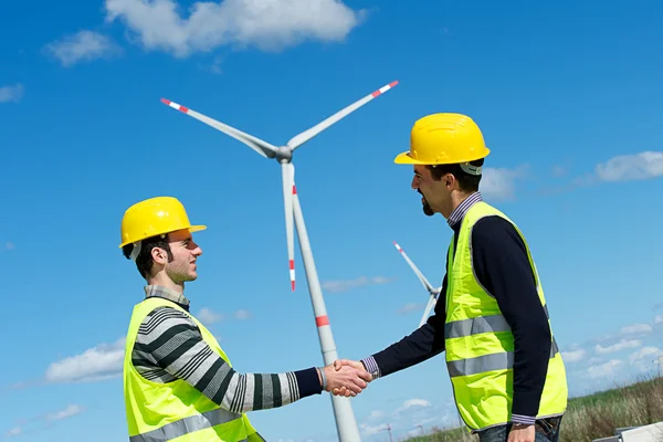 Інженери, даючи рукостискання в електростанція вітрових турбін — стокове фото