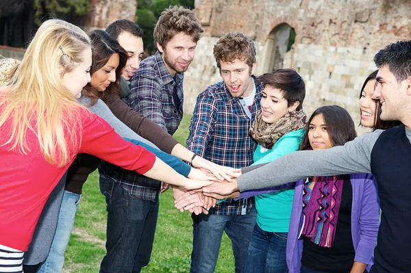 Estudiantes multirraciales con manos en la pila — Foto de Stock