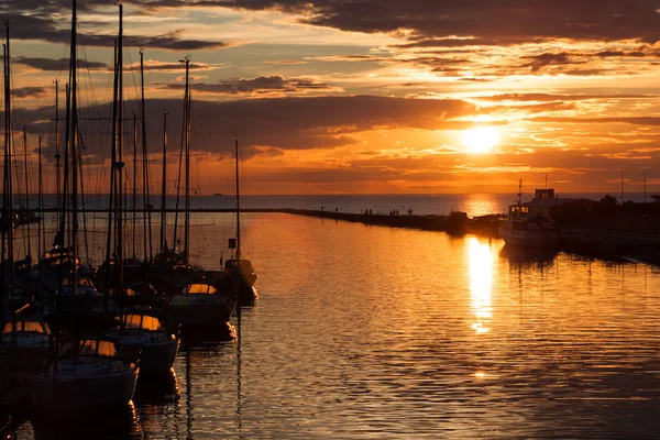 Segelbåtar silhuett i hamnen med solnedgång Royaltyfria Stockbilder