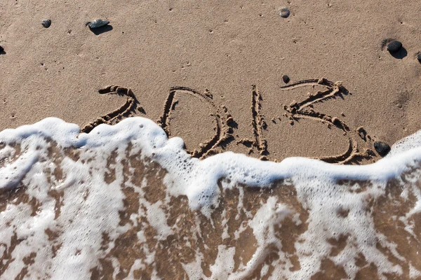 Números 2013 em areia de praia com água de onda — Fotografia de Stock