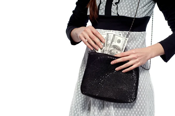 Молодая девушка вытаскивает доллары из сумки. На белом фоне — стоковое фото