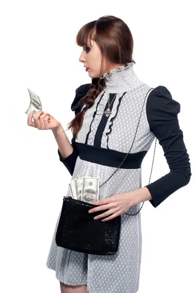 Una ragazzina guarda i soldi. Su sfondo bianco . — Foto Stock