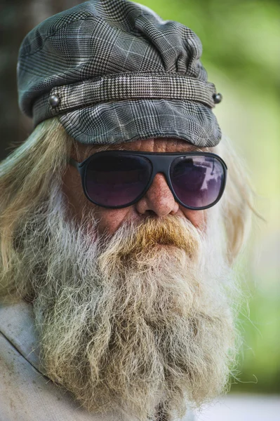 Homem barbudo com tampa & óculos de sol — Fotografia de Stock