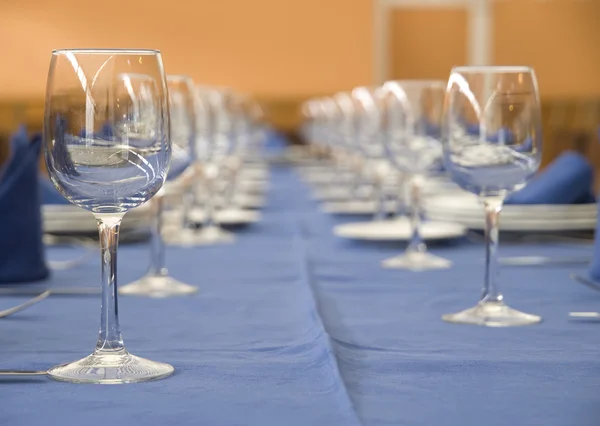 stock image A table with a row of glasses and cutlery