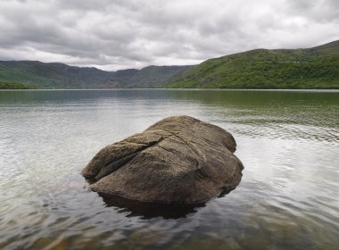 A lake with a rock in the middle clipart