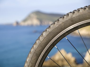 Mountain bike wheel with blurred landscape clipart