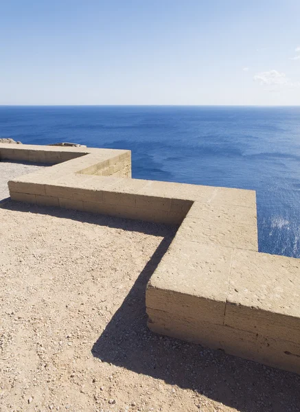 lindos Akropol yılında deniz manzarası ile alçak taş duvar