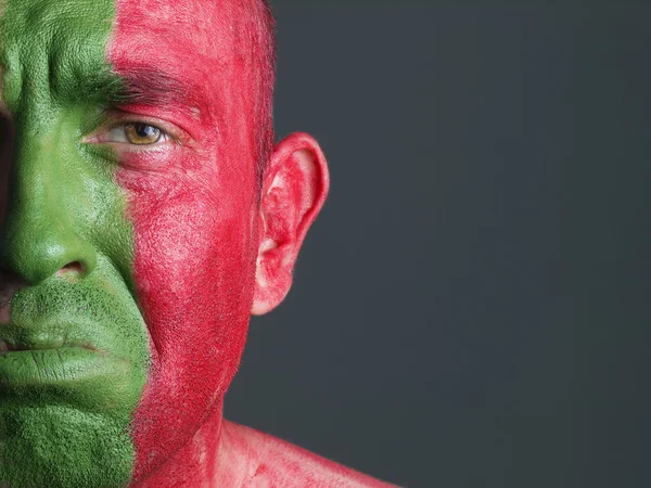 Man gezicht geschilderd vlag van portugal, triest expressie. — Stockfoto